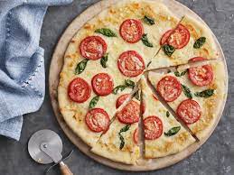 Tomates y albahaca en la pizza